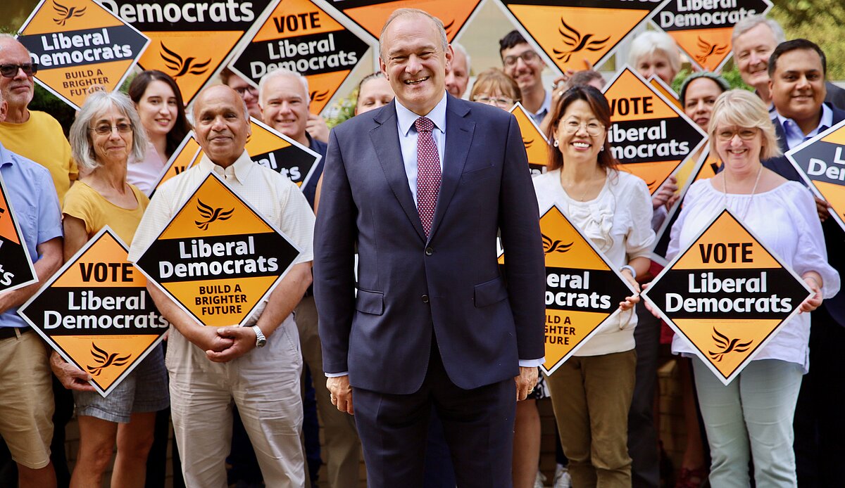 Ed Davey with a crowd holding Lib Dem signs