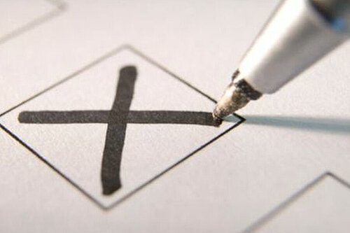 A pen marking an X vote in a box