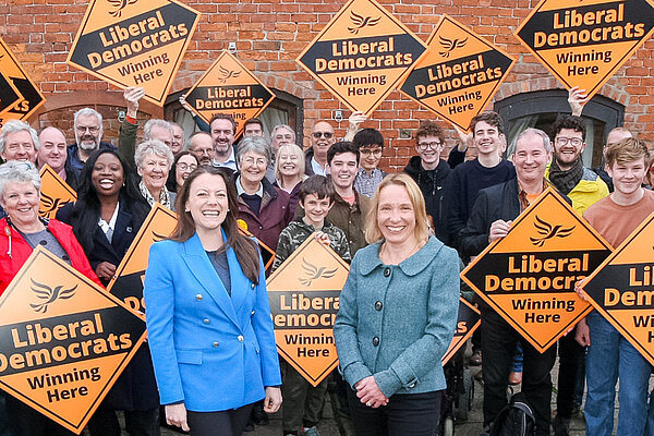 Sarah Green and Helen Morgan in front of a crowd holding Liberal Democrat posters