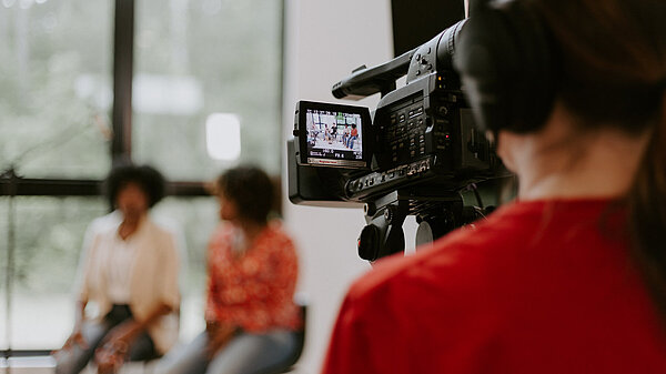 A TV camera operator filming two women