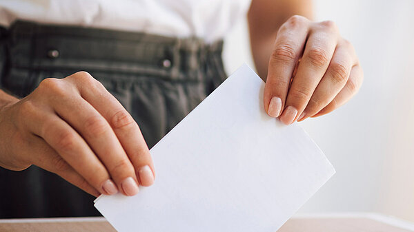 Federal Board representative 2024 A person putting a ballot paper into a ballot box