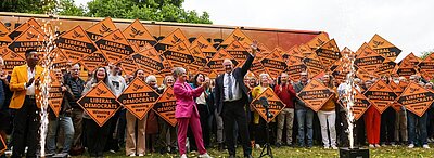 Ed Davey and Daisy Cooper with a crowd holding Lib Dem diamond signs
