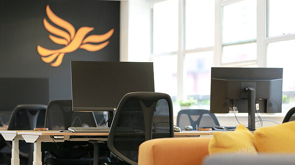 Desks a computers in front of a wall painted with the bird of liberty