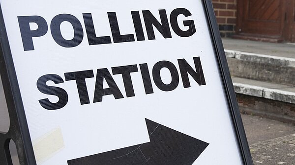 A sign with the words "POLLING STATION" and an arrow pointing to the right